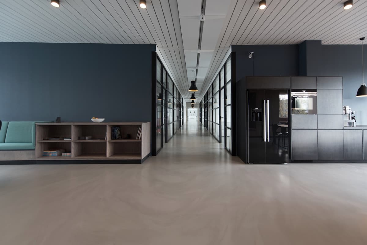 Empty modern office corridor in navy and charcoal tones, representing a consistent, structured process